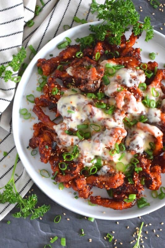 This crispy chicken is a Korean-inspired dish that is hot and spicy! Boneless and skinless thigh meat is dredged in cornstarch and fried until golden brown. Tossed in a vibrantly red and fiery sauce, Crispy Buldak Chicken is super flavourful and most certainly meant for the brave! #buldak #meltedcheese #korean #spicy #chicken #gochujang #gochugaru
