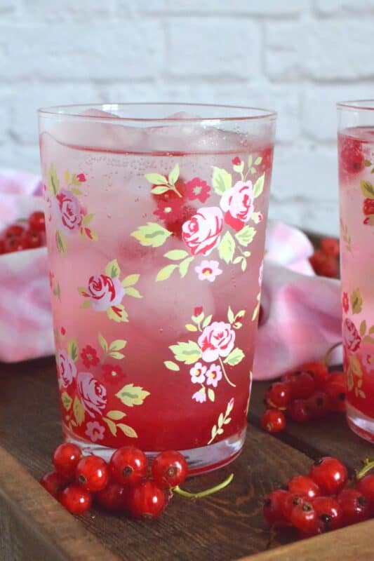 Cold, sweet, sparkling, and fizzy; this Red Currant Refresher starts with a red currant infused simple syrup and is stirred into lemon lime pop with lots of ice. Eat your heart out, Starbucks! Summer never tasted so good! #red #currant #redcurrants #currants #summer #drink #refresher