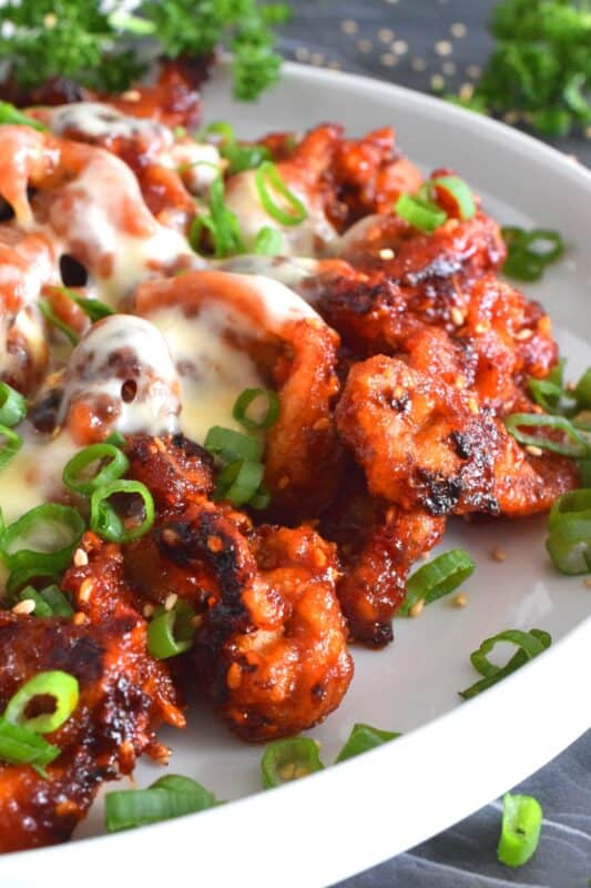 This crispy chicken is a Korean-inspired dish that is hot and spicy! Boneless and skinless thigh meat is dredged in cornstarch and fried until golden brown. Tossed in a vibrantly red and fiery sauce, Crispy Buldak Chicken is super flavourful and most certainly meant for the brave! #buldak #meltedcheese #korean #spicy #chicken #gochujang #gochugaru
