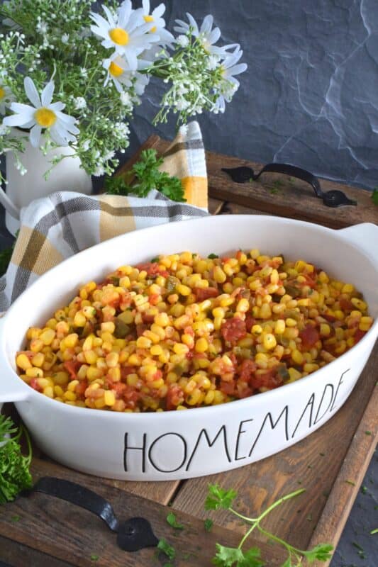 This warm and creamy corn salad is prepared with old bay seasoning, fried onions, bell peppers, garlic, and tomatoes. It's a perfect side dish for a backyard barbecue or a weeknight cold weather dinner. Serve with your favourite mains or spoon it onto grilled burgers and hot dogs. This side is versatile and delicious! #salad #corn #oldbay #creamedcorn #sidedish #vegetarian