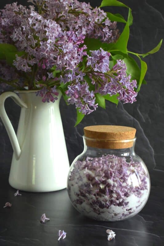 Lilac Infused Sugar is one of those things you didn't know you needed until you have it. Combine the two and watch the magic happen! Over the course of a few days, the sugar strips the lilac petals of all their moisture and scent. The sugar can then be used anywhere sugar is used! #lilac #infused #sugar #lilacsugar #lilacrecipes #infusedsugar