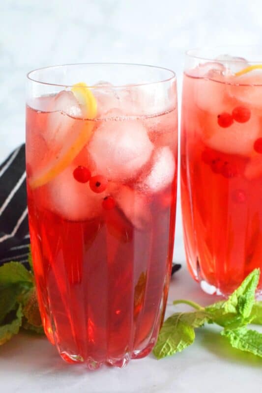 Patience needs to be practiced when making iced tea at home. Red Currant Iced Tea is prepared with just a few simple and inexpensive ingredients. Make a large pitcher of it and keep it super cold in your fridge, especially in early summer when red currant bushes are loaded down with the little, red, tart jewels! #icedtea #tea #redcurrants #currants #colddrinks #summerdrinks
