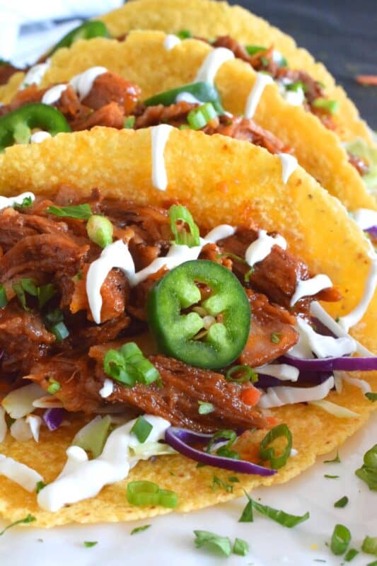 Moist and tender pork shoulder roast is braised in a rich and sweet tomato-based sauce with white wine, and brown sugar. The secret to these absolutely delicious Braised Pulled Pork Tacos is allowing the meat to cook slowly over low heat in a covered pan for multiple hours. Braising cannot be rushed and patience is greatly rewarded with just one bite of this deliciously savoury taco! #tacos #pulledpork #stovetop #castironcooking #dutchoven #porkshoulder #pork