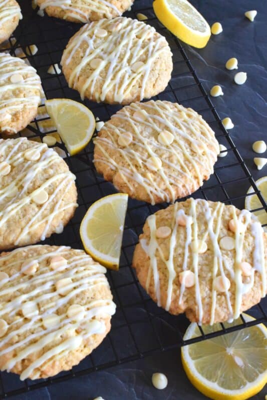 These cookies are both sweet and tart, and completely indulgent too! The flavour combination is created by pairing lemon zest and juice with oats, sugar, white chocolate chips, and vanilla pudding mix! Lemon Glazed Oatmeal White Chocolate Cookies are massively large, soft and chewy, and absolutely delicious! #lemon #oatmealcookies #cookies #glazed #tart #pudding