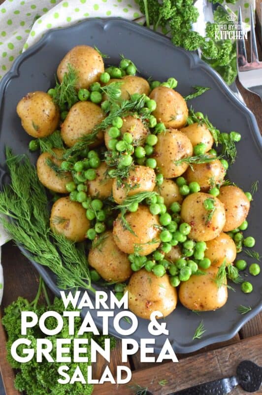 This warm salad consists of pillow-soft baby potatoes, bright green peas, and lots of fresh dill. These are tossed in a dressing prepared with olive oil, grainy mustard, champagne vinegar, and seasonings. Serve this dish anytime, because a really good potato salad is always a hit! #potatosalad #dill #babypotatoes #greenpeas #warmsalad
