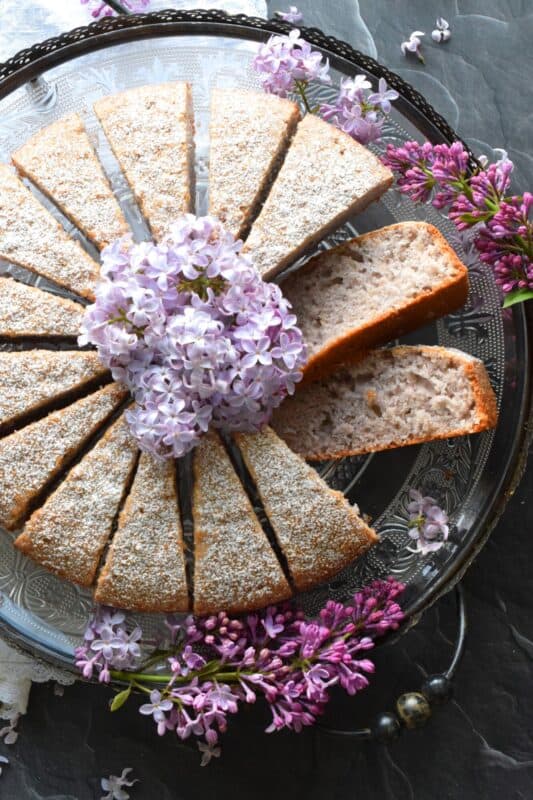 The old adage that simple is better certainly applies in the case of this Lilac Coffee Cake. A light dusting of confectioner's sugar and some gently placed lilac branches is all this moist and spongy cake needs to look superb! A perfect early summer treat, served with a tea or coffee - it really doesn't get any better! #lilac #edibleflowers #lilacs #cake #coffee #summer #spring #dessert