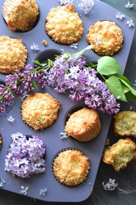 Mildly sweet Lilac Streusel Muffins are made with real lilac flowers, sweetened with homemade lilac sugar, and tinted with a floral, fragrant homemade lilac syrup. If that wasn't enough, the streusel crumb topping is super easy to make and adds a nice flaky crunch to the top of the deliciously soft and moist muffin! #lilac #streusel #muffins #lilacs #edibleflowers #crumbtopping