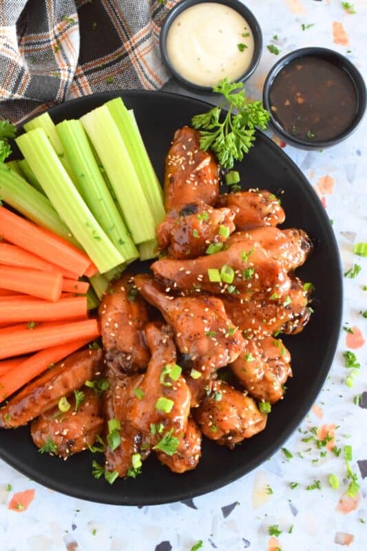 These chicken wings are first baked to golden perfection before being tossed in the most delicious sticky, sweet sauce. The sauce is made from scratch in just a few minutes, and with its sweet, tangy, savoury, and salty flavour, these Honeyed Teriyaki Wings are the absolute best! #wings #chickenwings #teriyaki #honey #honeyed #bakednotfried
