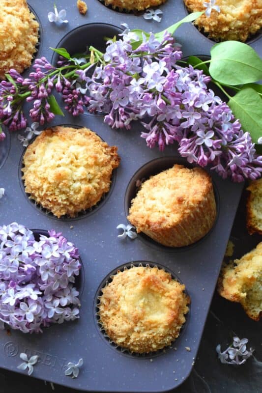 Mildly sweet Lilac Streusel Muffins are made with real lilac flowers, sweetened with homemade lilac sugar, and tinted with a floral, fragrant homemade lilac syrup. If that wasn't enough, the streusel crumb topping is super easy to make and adds a nice flaky crunch to the top of the deliciously soft and moist muffin! #lilac #streusel #muffins #lilacs #edibleflowers #crumbtopping