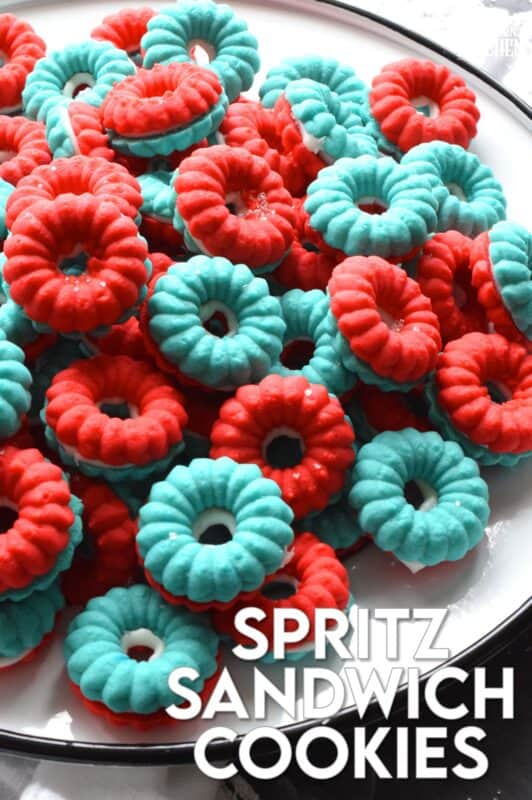 Everyone loves a spritz cookie, especially at Christmas! But, why should they only make an appearance once a year? In this version, I've coloured the cookie dough red and blue and sandwiched them with white frosting. These are most certainly bright and festive - perfect for your 4th of July celebrations! #spritz #cookies #sandwichcookies #redwhiteblue #4thofjuly #redwhiteandblue