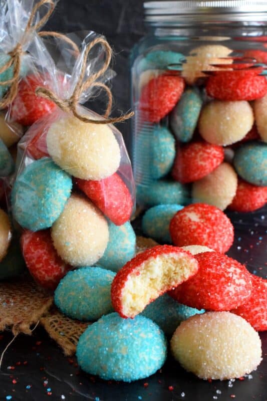 Just in time for your 4th of July celebration, these melt-in-your-mouth Red White and Blue Cookies are about to steal the spotlight with their sparkling beauty and their delicious taste! With just 5 ingredients, these cookies are not only easy to make, they're pretty to look at too! #redwhiteandblue #4thofjuly #independenceday #cookies #treats #sprinkles