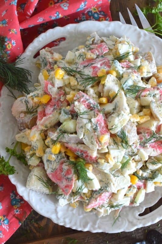 Chunky potatoes, flaky crab, crisp corn, crunchy cucumber, and chopped hard-boiled eggs make up this Imitation Crab and Potato Salad. A savoury, creamy, smooth dressing consisting of mayonnaise, fresh dill, champagne vinegar, and a few other ingredients brings the salad together in a cohesive, deliciously incredible dish! #crab #seafood #potatosalad #imitationcrab #summerside