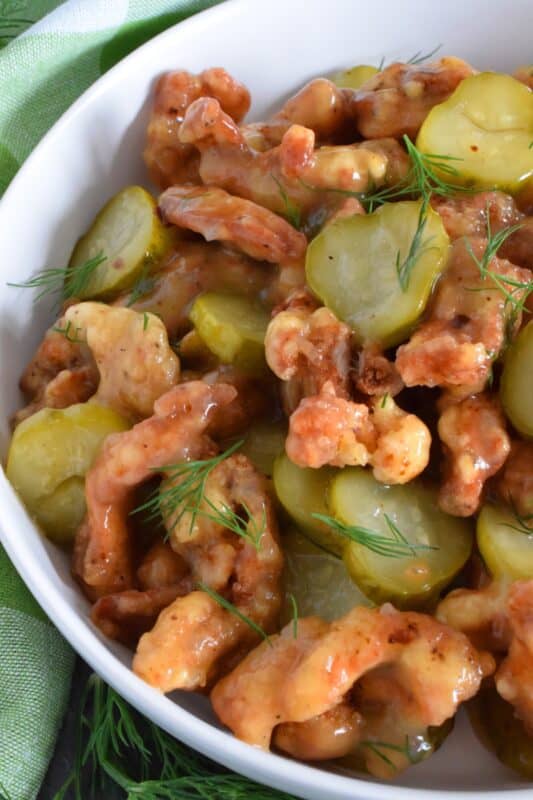 Sounds odd, right!? But, if you love dill pickles and you love fried chicken, you'll love this recipe! Boneless, skinless chicken thighs are marinated in jarred dill pickle juice and then fried with a light and crispy coating. Tossed in a sweet, dill pickle sauce with sliced pickles, Fried Dill Pickle Chicken is about as pickley as anything can get! #dill #dillpickle #chicken #friedchicken #picklebrine