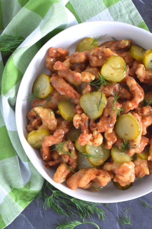 Sounds odd, right!? But, if you love dill pickles and you love fried chicken, you'll love this recipe! Boneless, skinless chicken thighs are marinated in jarred dill pickle juice and then fried with a light and crispy coating. Tossed in a sweet, dill pickle sauce with sliced pickles, Fried Dill Pickle Chicken is about as pickley as anything can get! #dill #dillpickle #chicken #friedchicken #picklebrine