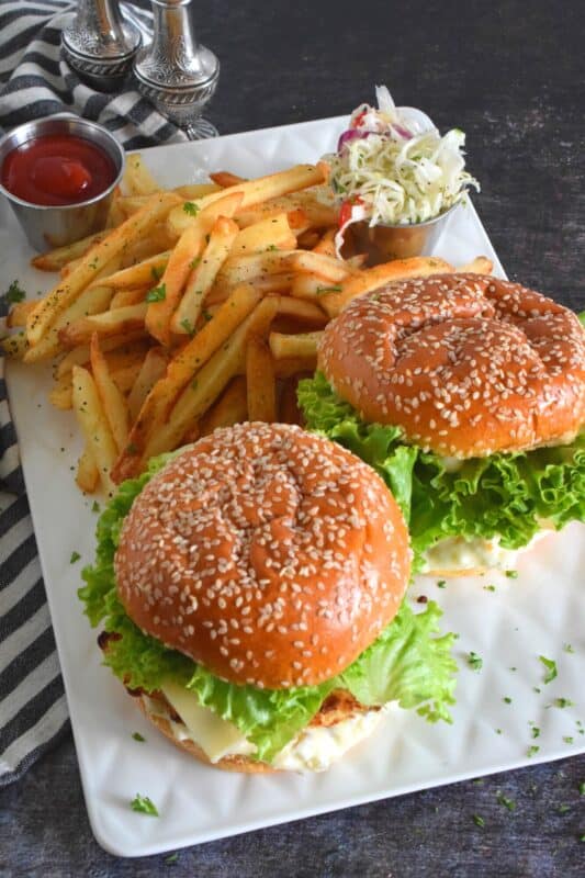 There's no room for mechanically processed fish burgers here! This burger is made with a fresh cod fillet that has been baked to a crispy perfection with a light and airy batter made with buttermilk and panko. Sandwiched between a brioche bun with lettuce and cheese, these Baked Crispy Cod Burgers are the absolute best! #copycat #fishfillet #fish #burger #seafood #bakednotfried