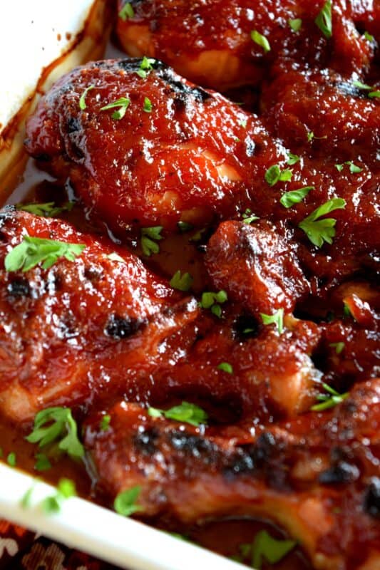 In this Charred Chipotle Chicken recipe, inexpensive drumsticks are baked with onion and then topped with a thick, sweet sauce consisting of chipotle peppers in adobo sauce, vinegar, brown sugar, and more. This is certainly an easily family pleasing main! #bakedchicken #drumsticks #spicychicken #chipotle #adobosauce #saucy