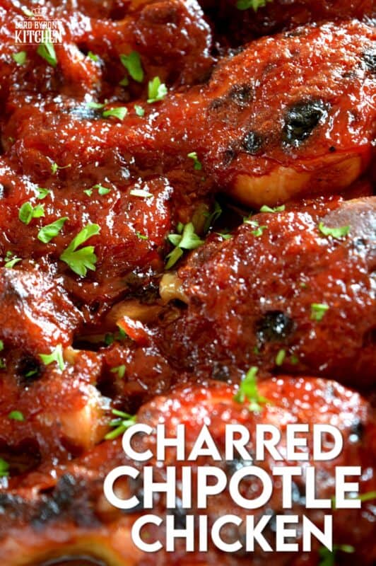 In this Charred Chipotle Chicken recipe, inexpensive drumsticks are baked with onion and then topped with a thick, sweet sauce consisting of chipotle peppers in adobo sauce, vinegar, brown sugar, and more. This is certainly an easily family pleasing main! #bakedchicken #drumsticks #spicychicken #chipotle #adobosauce #saucy