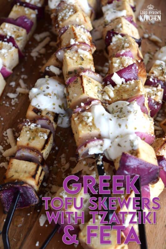 Extra firm tofu is marinated with red onion in a mixture of olive oil and the best quick and easy homemade Greek seasoning.  Grilled until slightly charred and topped with tzatziki and crumbled feta, these skewers are a great grilled meat alternative! #grilledtofu #tofu #greekrecipes #vegetarian #summergrilling