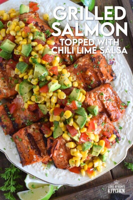 Salmon fillets are marinated in olive oil with honey, lime juice, seasonings, and spices then grilled until charred, yet still light and flaky on the inside. Topped with a salsa consisting of avocado, corn, tomatoes, and lime, this grilled salmon is not only refreshing and delicious, but also quite a beautiful and impressive main for you and your family this summer! #salmon #grillesalmon #chililime #salsa #summermeals #grilled #seafood