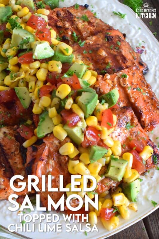Salmon fillets are marinated in olive oil with honey, lime juice, seasonings, and spices then grilled until charred, yet still light and flaky on the inside. Topped with a salsa consisting of avocado, corn, tomatoes, and lime, this grilled salmon is not only refreshing and delicious, but also quite a beautiful and impressive main for you and your family this summer! #salmon #grillesalmon #chililime #salsa #summermeals #grilled #seafood