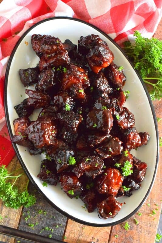 Barbecued Smoked Pork Belly Burnt Ends are prepared with trimmed and cubed pork belly which has been dry rubbed with a sweet spice blend. The pork is smoked with apple wood before being tossed with sauce and returned to the smoker to char up. #porkbelly #smoked #smoker #smokedrecipes #bbq #smokedpork #burntends