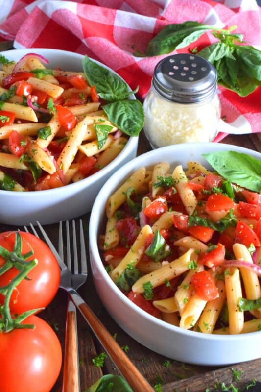 This is the ultimate summer pasta salad! Fresh tomatoes are marinated with olive oil, garlic, red onions, and balsamic vinegar before being tossed with cooked pasta and fresh basil. A terrific way to use your best summer fresh tomatoes! #pasta #summerpasta #bruschetta #pastasalad #tomatoes #summertomatoes #tomatorecipes