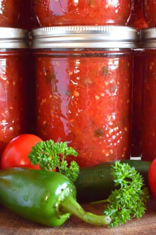 Fire roasted tomatoes and chilies are what make up the bulk of Canned Rotel Style Tomatoes. They can be either mild or spicy, depending on your personal preference. Add a jar of these tomatoes to pasta sauce, chili, casseroles, and even bean dip! The possibilities are endless and the flavour is tremendous! Make a batch with your locally grown, summer-fresh tomatoes and stock your pantry for the winter! #rotel #canned #tomatoes #preserved #preserving #canning