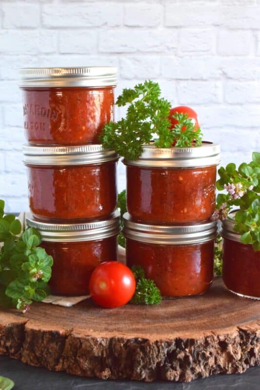 A really good pizza comes down to two things - the dough and the sauce. The topping are secondary to those! Canned Pizza Sauce is the answer to preparing a pizzeria style pizza at home. Make a batch, store it in your pantry, and make delicious pizzas at home for a fraction of the cost! #pizza #pizzasauce #canning #preserving #pantry #tomatoes