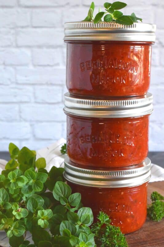 A really good pizza comes down to two things - the dough and the sauce. The topping are secondary to those! Canned Pizza Sauce is the answer to preparing a pizzeria style pizza at home. Make a batch, store it in your pantry, and make delicious pizzas at home for a fraction of the cost! #pizza #pizzasauce #canning #preserving #pantry #tomatoes