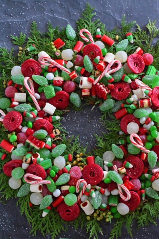 Prepare a Holiday Candy Wreath this Christmas and impress both the young and old kids in your home! Using as many red, green, and white candies as you can source, this bright and festive edible wreath is packed full of sweets! Set this up in the middle of your dessert buffet table, right on your kitchen island, or in the middle of your coffee table! Not only is it tasty, it also doubles as a decorative centerpiece! #wreath #candy #christmas #holiday #fingerfoods #party