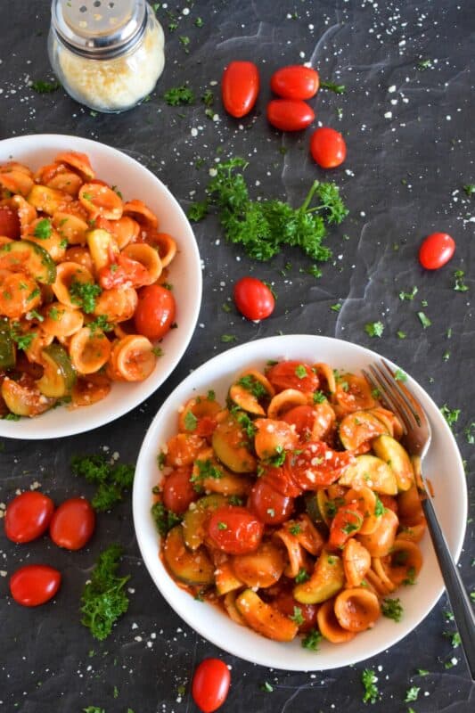 Two of the most common home-grown summer produce are tomatoes and zucchini. Harvest to your hearts' content and prepare copious amounts of this Tomato Zucchini Pasta. It's simple, it's healthy, and it's wonderfully delicious! Just one taste, and this will be a 30-minute recipe you will want to prepare repeatedly! #pasta #tomatoes #zucchini #meatlessmonday #vegetarian #summer #cherry #fresh #orecchiette #familyrecipes