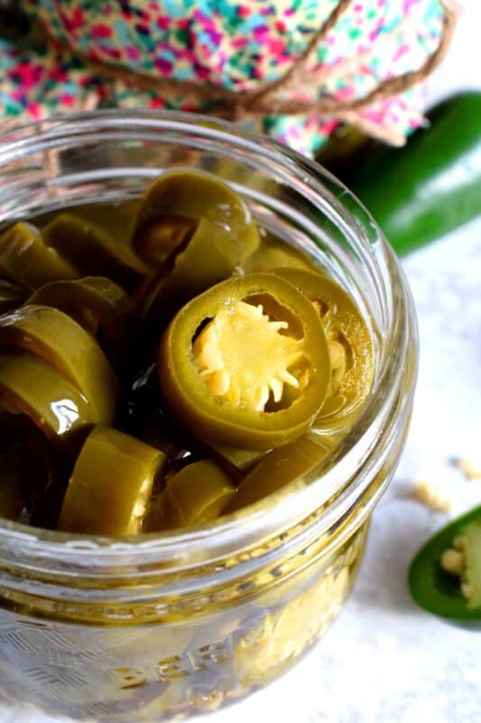 Preserved Candied Jalapenos are bite-sized morsels of heat and sweet - these are highly addictive, easy to prepare, and are a great addition to so many of your favourite recipes! This recipe makes four jars, but can easily be doubled or tripled if you feel like sharing! These make a great bring-along hostess gift too! #jalapenos #pickled #preserved #waterbath #canning