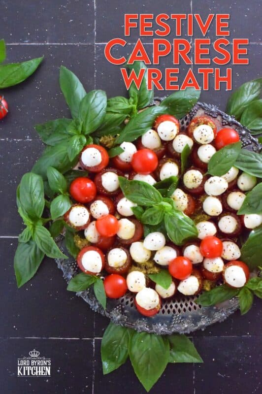 Simple, sweet, and cheesy!? You bet! This gorgeous Festive Caprese Wreath is easily prepared with hollowed-out cherry tomatoes stuffed with basil pesto and mini bocconcini. Sprinkle over some freshly ground black pepper, drizzle with olive oil, and tuck in some fresh basil leaves before serving! #festive #caprese #ediblewreath #tomatoes #bocconcini