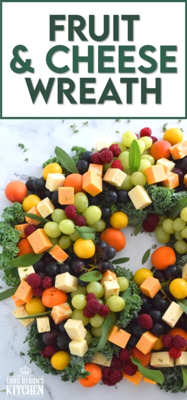 An edible wreath consisting of red and green grapes, fresh apricots, tart plums, vibrantly red raspberries, and various types of cheese, this beautifully festive Fruit and Cheese Wreath is a wonderful way to display and serve your guests this holiday season! #christmas #holiday #fingerfoods #appetizers #cheeseplatter #charcuterie #grazing #board