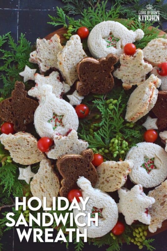 The sandwiches that make up this Holiday Sandwich Wreath are small, delicious, and festively shaped with your favourite cookie cutters. With four different flavours, there's one for everyone! Serve these finger sandwiches with a cup of hot tea at an afternoon holiday gathering! #sandwiches #fingerfoods #charcuterie #christmas #holiday #nobake