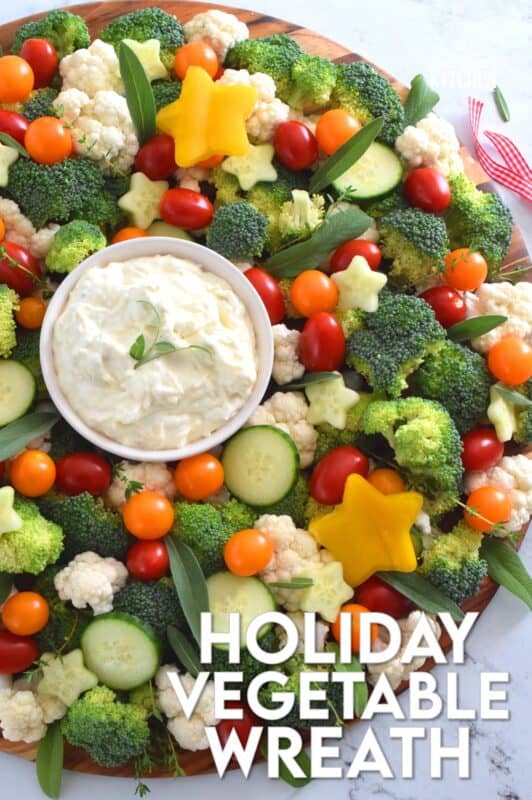 Every party needs a platter or two of finger foods for everyone to munch on. No matter what type of party you're hosting, it most certainly needs a Holiday Vegetable Wreath platter. This gorgeous wreath is prepared using fresh broccoli, cauliflower, tomatoes, cucumbers, and more! Serve with your favourite vegetable dip! #christmas #holiday #partyfood #appetizers #veggieplatter #veggies