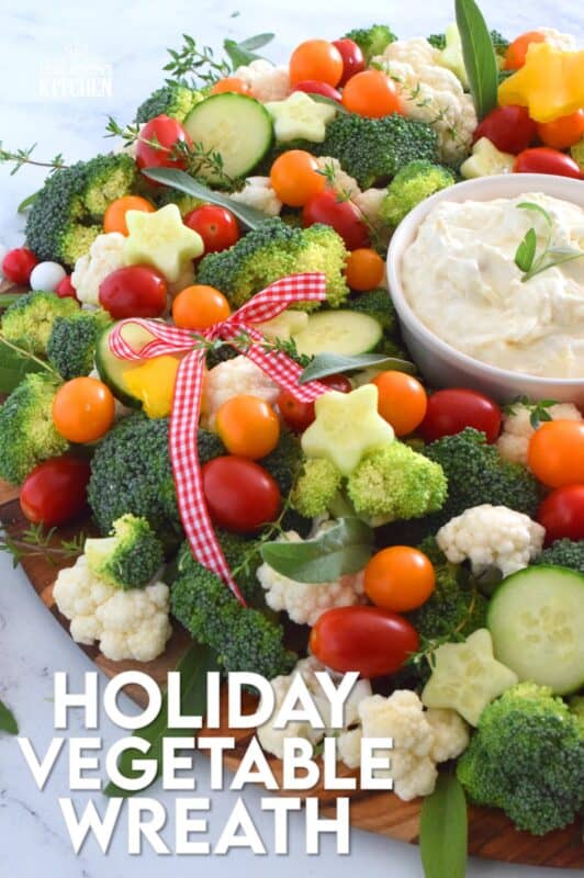 Every party needs a platter or two of finger foods for everyone to munch on. No matter what type of party you're hosting, it most certainly needs a Holiday Vegetable Wreath platter. This gorgeous wreath is prepared using fresh broccoli, cauliflower, tomatoes, cucumbers, and more! Serve with your favourite vegetable dip! #christmas #holiday #partyfood #appetizers #veggieplatter #veggies