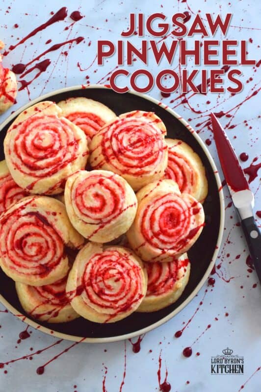Despite their horror-ish name and their bloody demeanour, Jigsaw Pinwheel Cookies are a light and buttery delight! Liberally dusted with red sanding sugar, the biscuit-like dough is rolled to form the look of Jigsaw's red and white spirally cheeks. Complete with a splattering of homemade edible blood, these cookies are perfect for Halloween and the Saw franchise fan! #jigsaw #saw #sawmovie #halloween #cookies #edible #blood