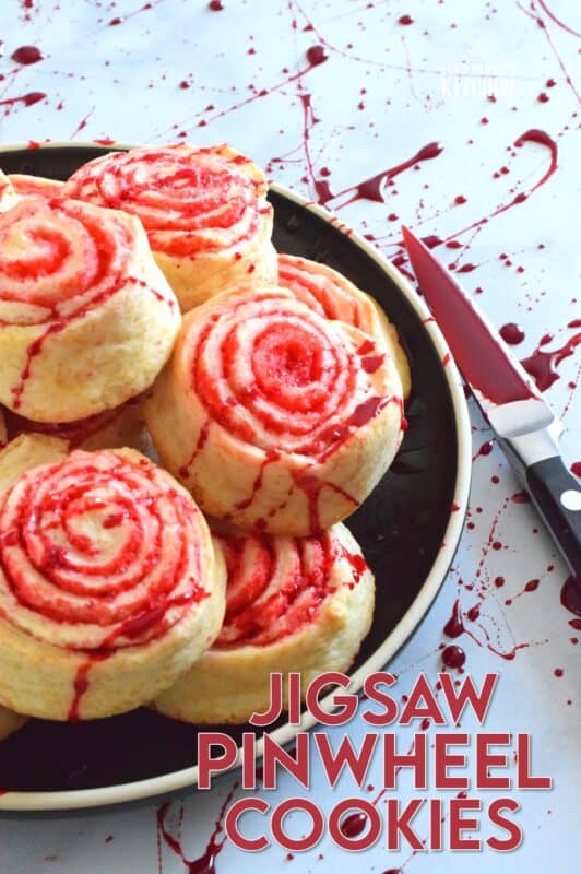 Despite their horror-ish name and their bloody demeanour, Jigsaw Pinwheel Cookies are a light and buttery delight! Liberally dusted with red sanding sugar, the biscuit-like dough is rolled to form the look of Jigsaw's red and white spirally cheeks. Complete with a splattering of homemade edible blood, these cookies are perfect for Halloween and the Saw franchise fan! #jigsaw #saw #sawmovie #halloween #cookies #edible #blood