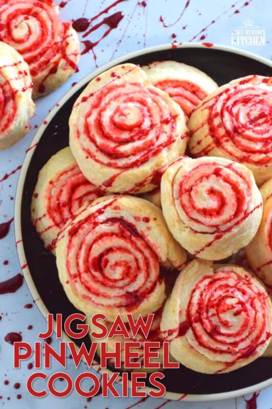 Despite their horror-ish name and their bloody demeanour, Jigsaw Pinwheel Cookies are a light and buttery delight! Liberally dusted with red sanding sugar, the biscuit-like dough is rolled to form the look of Jigsaw's red and white spirally cheeks. Complete with a splattering of homemade edible blood, these cookies are perfect for Halloween and the Saw franchise fan! #jigsaw #saw #sawmovie #halloween #cookies #edible #blood