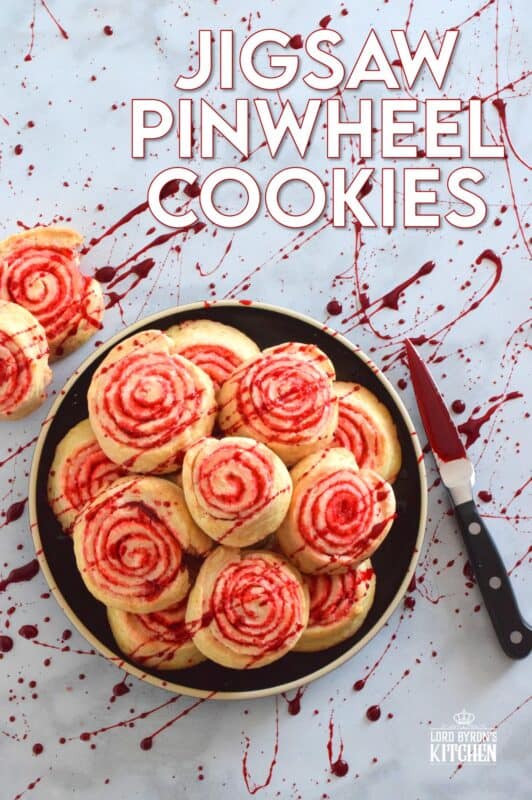 Despite their horror-ish name and their bloody demeanour, Jigsaw Pinwheel Cookies are a light and buttery delight! Liberally dusted with red sanding sugar, the biscuit-like dough is rolled to form the look of Jigsaw's red and white spirally cheeks. Complete with a splattering of homemade edible blood, these cookies are perfect for Halloween and the Saw franchise fan! #jigsaw #saw #sawmovie #halloween #cookies #edible #blood