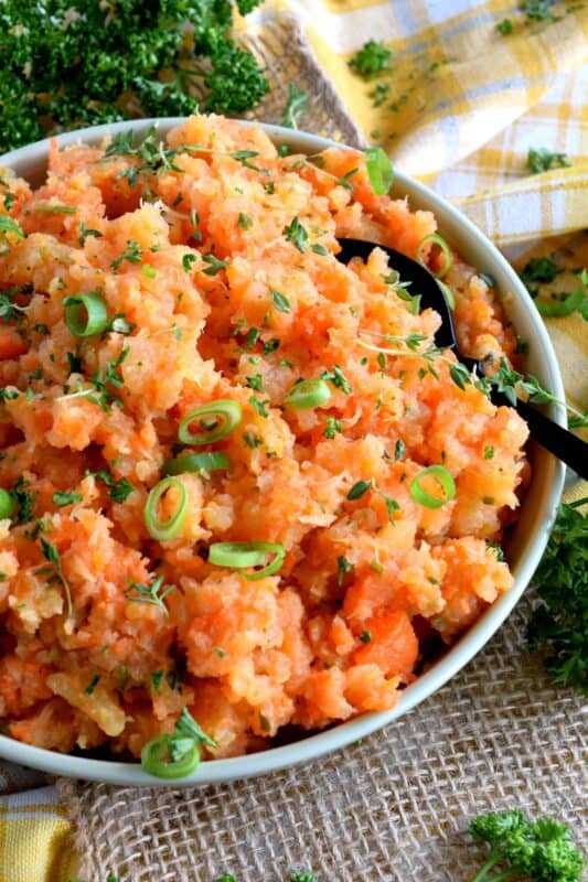 Nothing compares to the rustic simplicity of Mashed Turnip and Carrots with Herb Butter. Comforting and wholesome, it will add a pop of colour and flavour to any autumn dinner. Serve this side at Thanksgiving - it's delicious with gravy too! #mashed #turnip #carrot #vegetable #sidedish