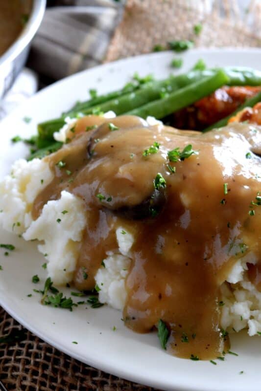 A good gravy is a must-have for the home chef. Vegetarian Mushroom Gravy is not only for vegetarians; it's thick and hearty, and loaded with mushrooms and herbs. Here's an easy meatless gravy that's the perfect condiment for any palate. #gravy #mushroom #mushroomgravy #vegetarian #vegetariangravy #thanksgiving