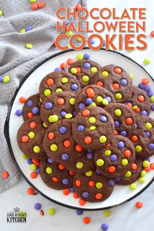 Chocolate Halloween Cookies have a slightly crispy exterior with a dense chocolaty center. Stuffed with white chocolate chips and topped with green, purple, and orange M&M candy, these cookies are both delicious and festive!  Your little trick-or-treaters are going to love these! #m&m #halloween #cookies #chocolate #trickortreat