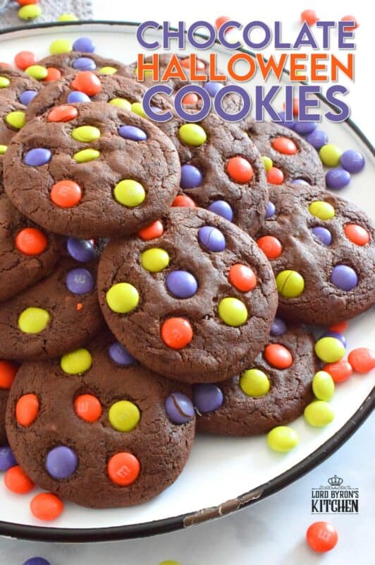 Chocolate Halloween Cookies have a slightly crispy exterior with a dense chocolaty center. Stuffed with white chocolate chips and topped with green, purple, and orange M&M candy, these cookies are both delicious and festive!  Your little trick-or-treaters are going to love these! #m&m #halloween #cookies #chocolate #trickortreat