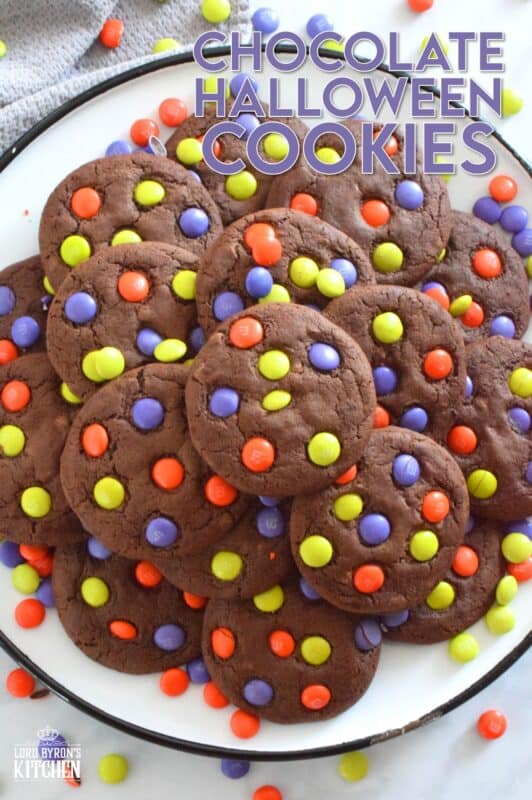 Chocolate Halloween Cookies have a slightly crispy exterior with a dense chocolaty center. Stuffed with white chocolate chips and topped with green, purple, and orange M&M candy, these cookies are both delicious and festive!  Your little trick-or-treaters are going to love these! #m&m #halloween #cookies #chocolate #trickortreat