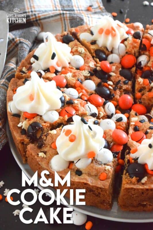 One giant cookie that eats like a cake, this M&M Cookie Cake is perfect when served with a dollop of frosting on each slice. Loaded with candy-coated chocolate and autumn sprinkles, this cake is a fun dessert the whole family will love! #M&M #halloween #cookie #cake #chocolate