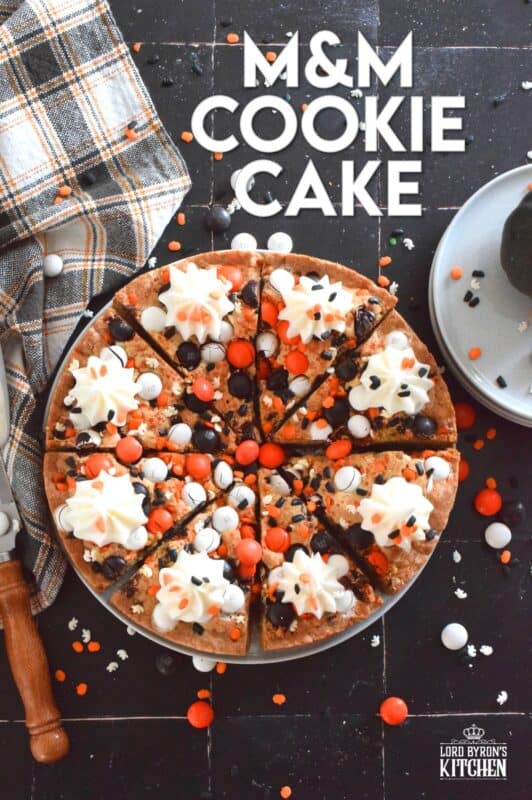 One giant cookie that eats like a cake, this M&M Cookie Cake is perfect when served with a dollop of frosting on each slice. Loaded with candy-coated chocolate and autumn sprinkles, this cake is a fun dessert the whole family will love! #M&M #halloween #cookie #cake #chocolate