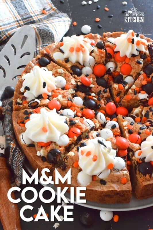 One giant cookie that eats like a cake, this M&M Cookie Cake is perfect when served with a dollop of frosting on each slice. Loaded with candy-coated chocolate and autumn sprinkles, this cake is a fun dessert the whole family will love! #M&M #halloween #cookie #cake #chocolate