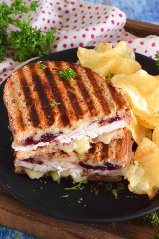 Stuffed to the max with sliced turkey, crispy bacon, and cranberry sauce, this Bacon and Turkey Panini is very moist and juicy. Oh, and it's also loaded with melted, gooey cheese! This sandwich is the best way to use up your Thanksgiving leftovers! If you don't have a panini press, don't worry; I have a solution! #sandwich #panini #grilledsandwich #paninipress #leftovers #turkey #bacon